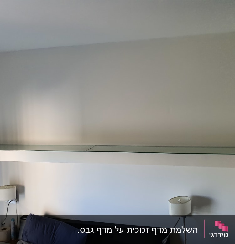 מדף זכוכית ארוך מותקן על קיר לבן